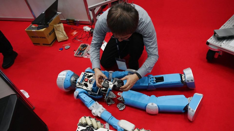 Humanoid robot being repaired at the International Robot Exhibition in Tokyo
